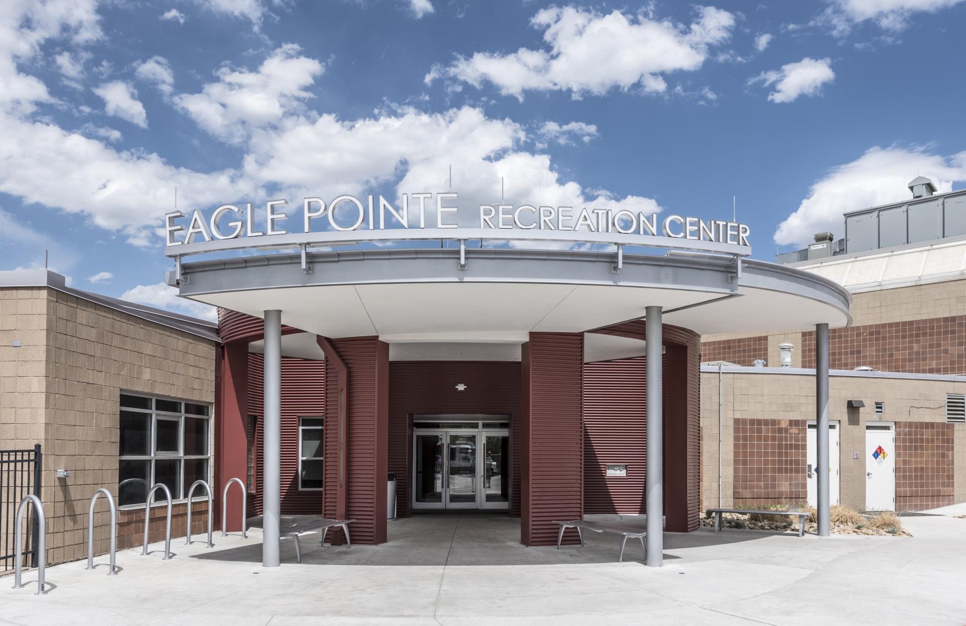 Picture of the Eagle Pointe Recreation Center Entrance with some clouds and blue skys above.