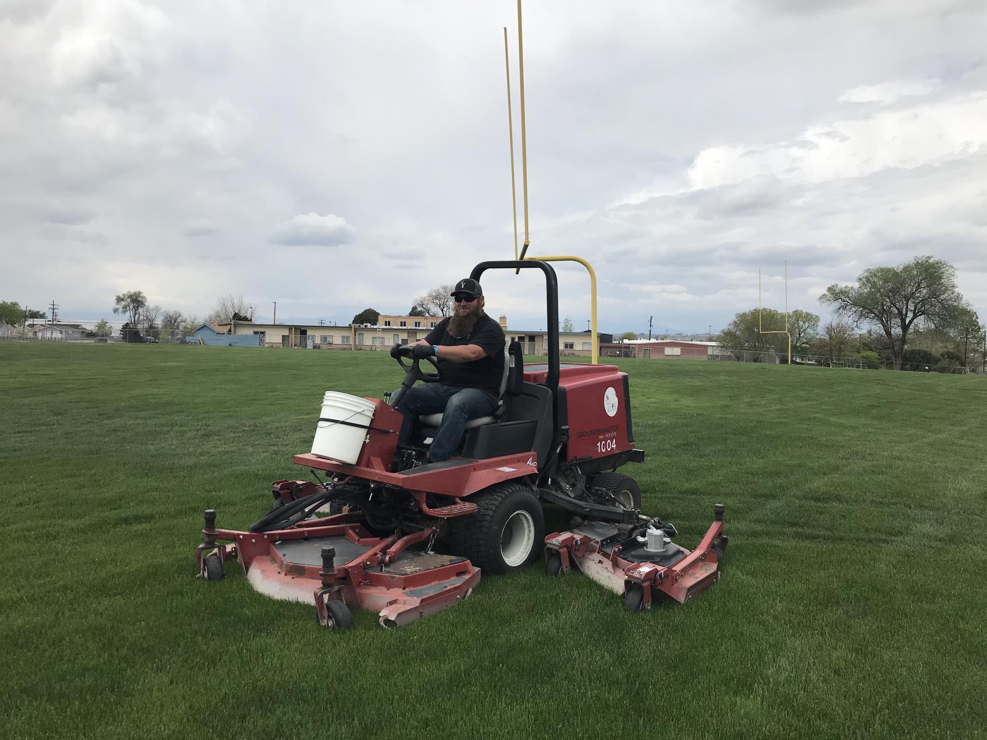 Parks photo Parks Worker working on Parks grounds on a red riding mower