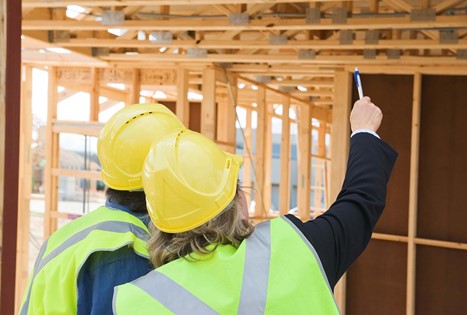 inspectors in a new building wearing hard hats and yellow vests